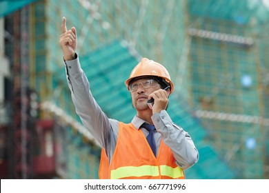 Supervisor managing building process with the help of walki-talkie