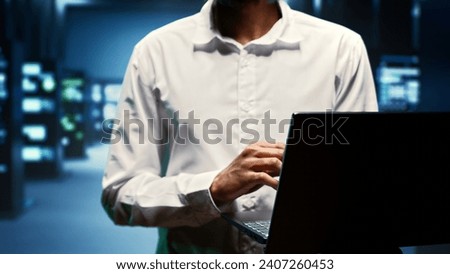 Supervisor walking between rackmounts in high performance computing server room, ensuring faultless operations conditions. Programmer monitoring data center devices energy consumption, close up