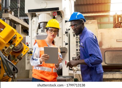 Supervisor, Worker With Hard Hat Working In Manufacturing Factory On Business Day. Female Industrial Engineers Have To Consult With Colleagues While Using Tablet. Concept Of Workplace Gender Equality