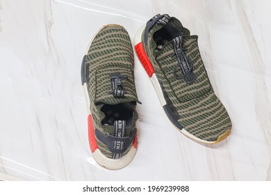 SUPHANBURI THAILAND - 6 MAY 2021: The green Adidas NMD TS1 shoes are beautiful and stylish fans are placed on beautiful scenes in and captured in Thailand.