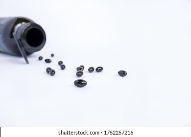 Supplement for a healthy life, youth and energy. Black astaxanthin capsules on a light background. 