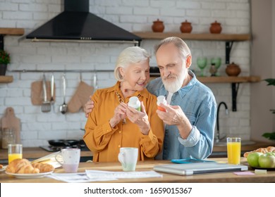 Supplements. Elderly married couple reading instruction for using supplement