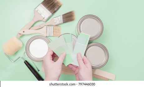 Supplies To Start House Painting Project. Metal Paint Cans, Paint Brushes, And Paint Swatches.