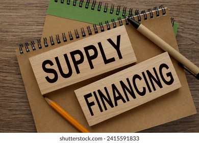 SUPPLY FINANCING text on wooden blocks on a notepad - Powered by Shutterstock