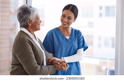 Support, caregiver with senior woman and holding hands for care indoors. Retirement, consulting and professional female nurse with elderly person smiling together for healthcare at nursing home - Powered by Shutterstock