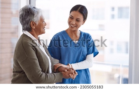 Support, caregiver with senior woman and holding hands for care indoors. Retirement, consulting and professional female nurse with elderly person smiling together for healthcare at nursing home