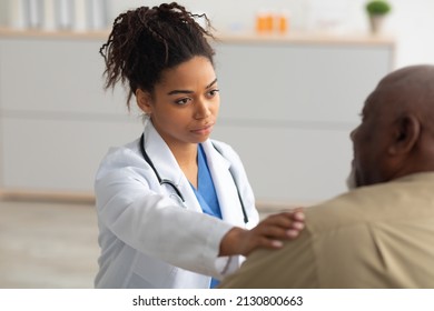 Support Concept. Portrait Of Black Female Doctor Tapping Patting Patient's Shoulder For Empathy And Encouragement During Appointment In Clinic. General Practitioner Cheering Mature Man At Office