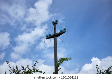 support with electricity cables with cables disconnected and dangling on the blue sky