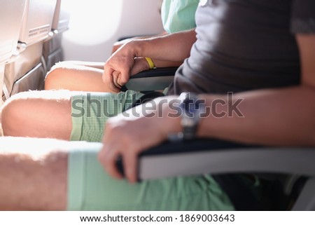 Support of fear of heights, and fear of flying in passenger seats in cabin. Stress when traveling by plane. Man hold woman hand in passenger seats in aircraft cabin.
