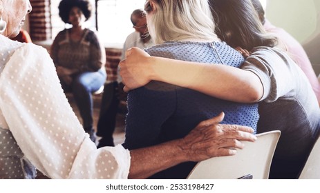 Support group meeting with diverse individuals sitting in a circle hugging and supporting one another. People offering comfort and empathy, showing support and connection in a community setting. - Powered by Shutterstock