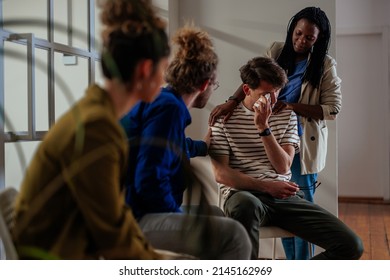 Support group multiracial patients comforting man at therapy session - Shutterstock ID 2145162969