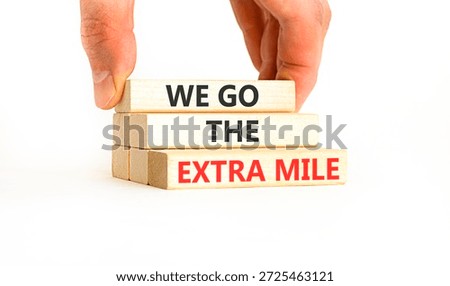 Support, help we go the extra mile symbol. Concept words We go the extra mile on beautiful wooden blocks. Beautiful white background. Business we go the extra mile concept. Copy space.