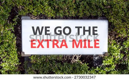 Support, help we go the extra mile symbol. Concept words We go the extra mile on white beautiful road sign. Beautiful green trees background. Business we go the extra mile concept. Copy space.
