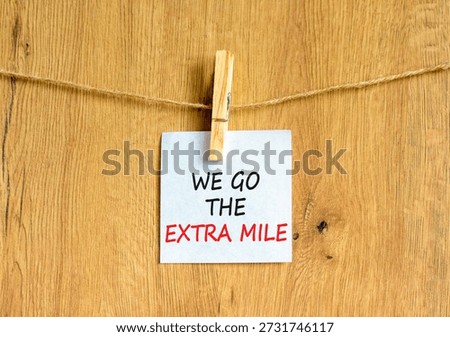 Support, help we go the extra mile symbol. Concept words We go the extra mile on beautiful white paper on clothespin. Beautiful wooden background. Business we go the extra mile concept. Copy space.