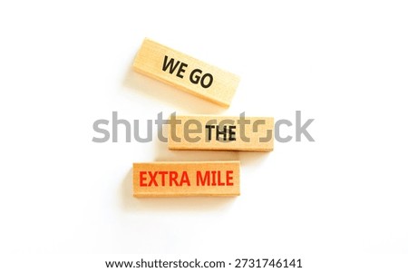 Support, help we go the extra mile symbol. Concept words We go the extra mile on beautiful wooden blocks. Beautiful white background. Business we go the extra mile concept. Copy space.