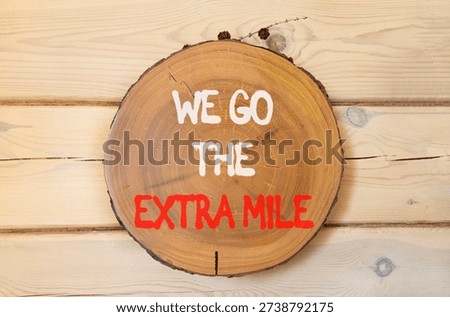 Support, help we go the extra mile symbol. Concept words We go the extra mile on beautiful wooden circle. Beautiful wooden wall background. Business we go the extra mile concept. Copy space.