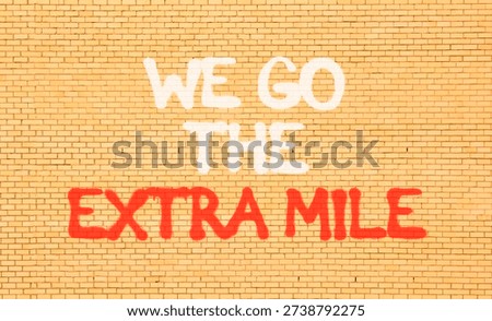 Support, help we go the extra mile symbol. Concept words We go the extra mile on beautiful brown brick wall. Beautiful brick wall background. Business we go the extra mile concept. Copy space.