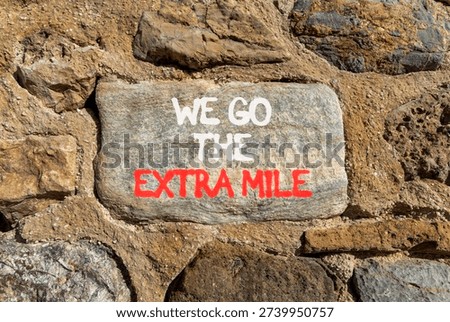 Support, help we go the extra mile symbol. Concept words We go the extra mile on beautiful grey stone. Beautiful stone wall background. Business we go the extra mile concept. Copy space.
