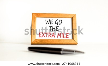 Support, help we go the extra mile symbol. Concept words We go the extra mile on beautiful wooden picture frame. Beautiful white background. Business we go the extra mile concept. Copy space.