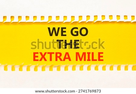 Support, help we go the extra mile symbol. Concept words We go the extra mile on beautiful yellow paper. Beautiful white paper background. Business we go the extra mile concept. Copy space.