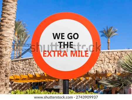Support, help we go the extra mile symbol. Concept words We go the extra mile on beautiful white road sign. Beautiful palm trees blue sky background. Business we go the extra mile concept. Copy space.