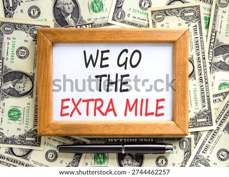 Support, help we go the extra mile symbol. Concept words We go the extra mile on beautiful wooden picture frame. Beautiful dollar bills background. Business we go the extra mile concept. Copy space.