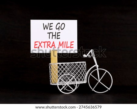 Support, help we go the extra mile symbol. Concept words We go the extra mile on beautiful white paper. Beautiful black background. Miniature bicycle. Business we go the extra mile concept Copy space