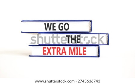 Support, help we go the extra mile symbol. Concept words We go the extra mile on beautiful books. Beautiful white paper background. Business we go the extra mile concept. Copy space.