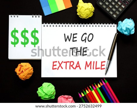 Support, help we go the extra mile symbol. Concept words We go the extra mile on beautiful white note. Beautiful black background. Black pen. Business we go the extra mile concept. Copy space.