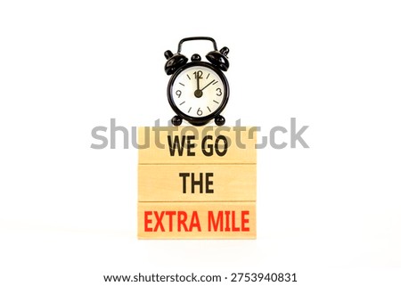 Support, help we go the extra mile symbol. Concept words We go the extra mile on beautiful wooden blocks. Beautiful white background. Black alarm clock. Business we go extra mile concept. Copy space.