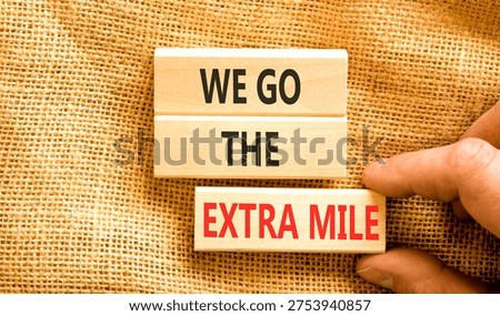 Support, help we go the extra mile symbol. Concept words We go the extra mile on beautiful wooden blocks. Beautiful canvas background. Business we go the extra mile concept. Copy space.