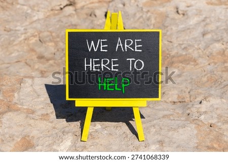 Support, help and we are here to help symbol. Concept words We are here to help on beautiful blackboard. Beautiful stone background. Business we are here to help concept. Copy space.