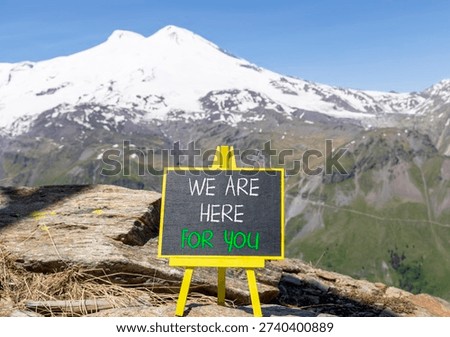 Support, help and we are here for you symbol. Concept words We are here for you on beautiful blackboard. Beautiful mountain Elbrus background. Business we are here for you concept. Copy space.