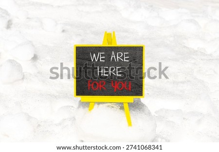 Support, help and we are here for you symbol. Concept words We are here for you on beautiful blackboard. Beautiful white snow background. Business we are here for you concept. Copy space.