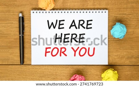 Support, help and we are here for you symbol. Concept words We are here for you on beautiful white note. Beautiful wooden background. Black pen. Business we are here for you concept. Copy space.