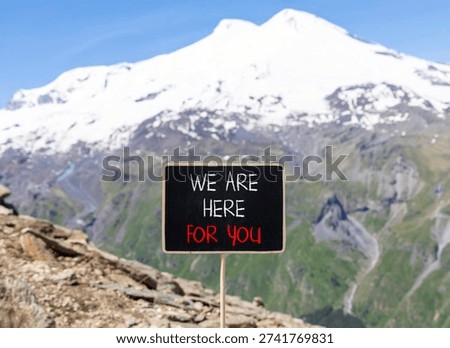 Support, help and we are here for you symbol. Concept words We are here for you on beautiful blackboard. Beautiful mountain Elbrus background. Business we are here for you concept. Copy space.