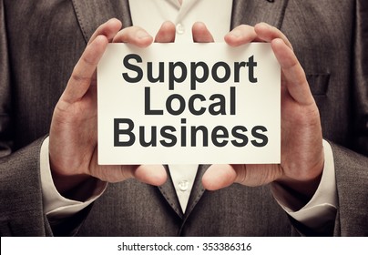 Support Local Business. Businessman holding a card with a message text written on it