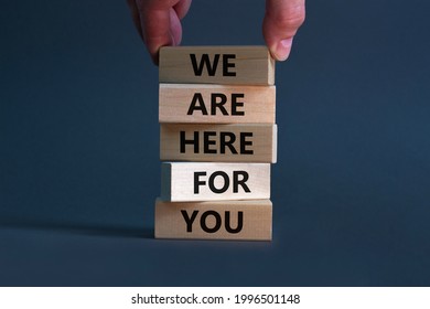 Support symbol. Wooden blocks with words 'we are here for you'. Businessman hand. Beautiful grey background, copy space. Business and support concept.