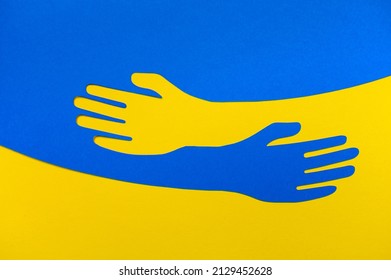 Apoyo a Ucrania. Icono de abrazo, abrazos de armas en colores de Ucrania, guerra en Ucrania, ataque de Rusia. Papercut, las manos abrazan la plantilla del logotipo del vector lineal. Cuidado, amor y símbolo de caridad, papel de mano