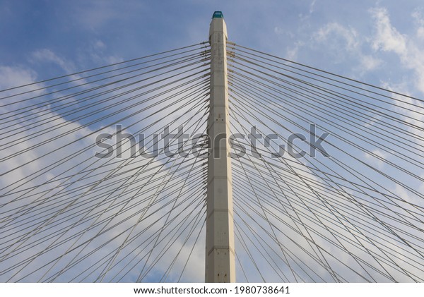 Supporting structure and steel\
ropes of the bridge with cloudy sky background. The cable braced\
bridge.