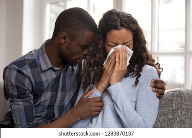 Supportive african husband embracing crying wife asking for forgiveness or consoling comforting helping sharing grief or problem, apology, compassion, empathy in black couple relationships concept