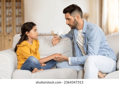 Supportive Arabic Dad Talking To Sad Preteen Daughter, Supporting Her In Childhood Struggles, Sitting On Couch, Explaining Something And Helping Cope With Adolescence Problems At Home - Powered by Shutterstock