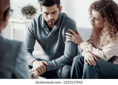 Supportive beautiful wife touching husband's arm during psychotherapy session for married couples with problems - Shutterstock ID 1255117942