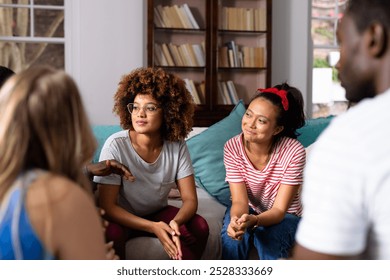 Supportive diverse friends smiling and listening to each other at group therapy session. Therapy, mental health, friendship and support, unaltered. - Powered by Shutterstock