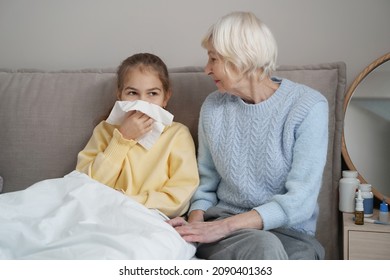 Supportive elderly lady sitting beside her sick granddaughter - Powered by Shutterstock