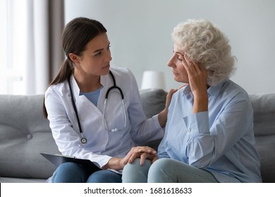 Supportive female nurse visit old grandmother patient at home listen to complains concerns, attentive young woman doctor consulting mature senior grandma, elderly medical healthcare concept