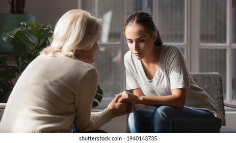 Supportive older Caucasian mom hold hands comfort caress talk with millennial female child feeling unhappy sad. Loving senior mother show support and care to upset depressed adult grownup daughter. - Powered by Shutterstock