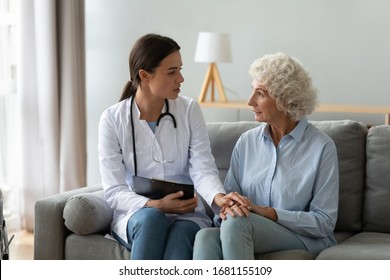 Supportive Young Woman Doctor Or Nurse Visit Senior Grandma Patient At Home Talk Consult, Attentive Female Caregiver Give Help To Elderly Mature Grandmother, Old People Healthcare Concept