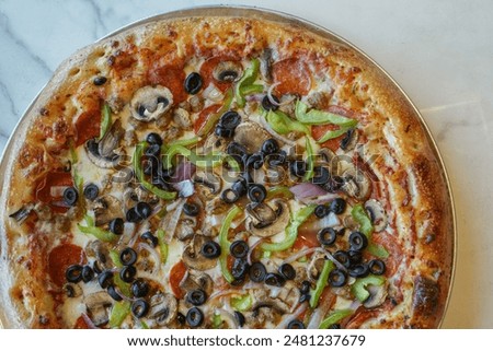 supreme pizza on a white marble background