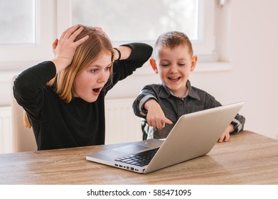 Suprised Kids Looking At Laptop Screen At Home